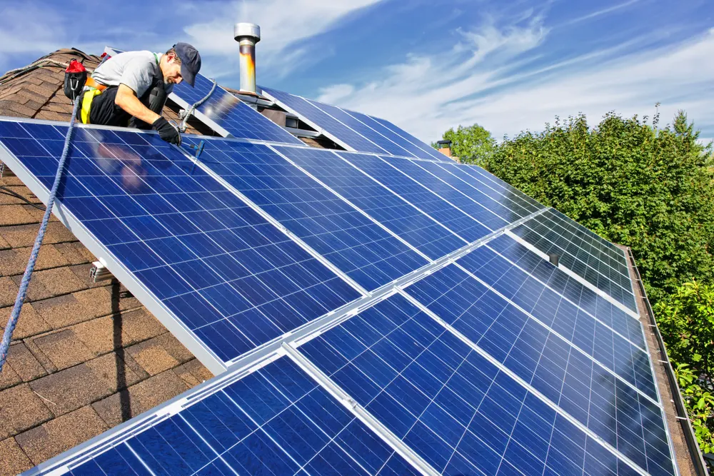 Solar technician installing rooftop panels